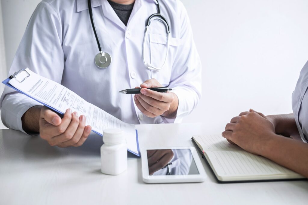 Doctor consulting with patient and checking sickness condition while presenting results diagnosis