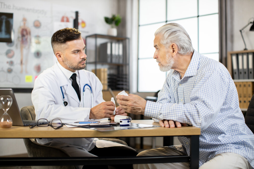 Male physician providing medical consultation to senior man. Geriatric medicine concept