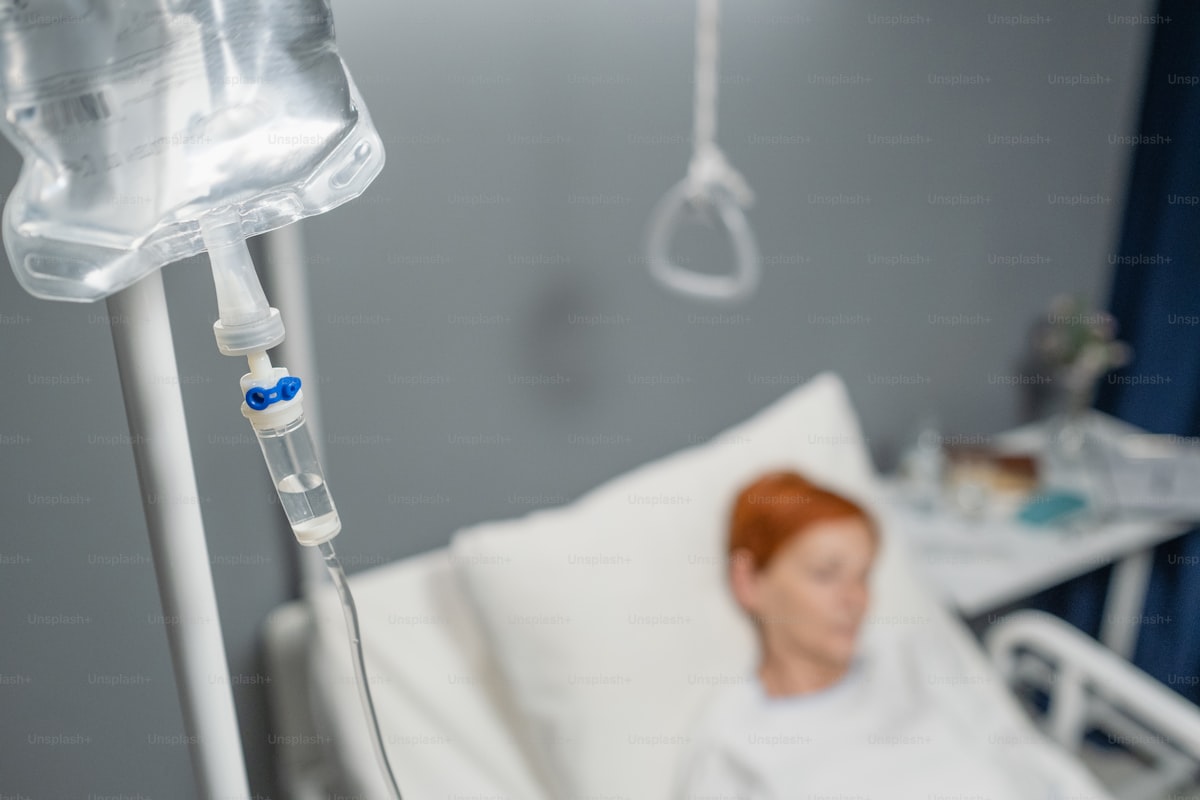 Healthcare professional preparing an IV infusion with vitamin supplements in a clinical setting